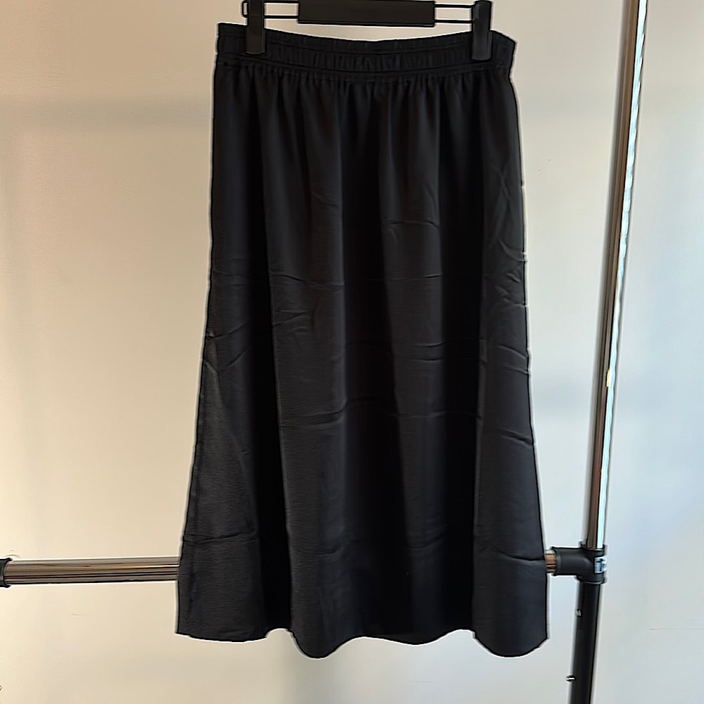 Black skirt with pockets. Satin-like finish. Never worn. H&M. Size 10.